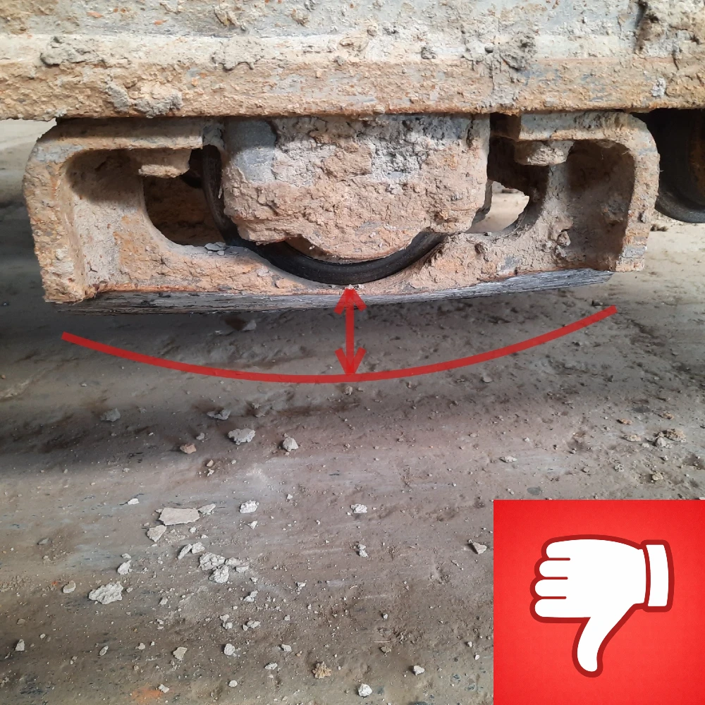 Slijtage aan de kettinggeleiders waarbij de geleider van het rijwerk in hoogte verminderd is.
