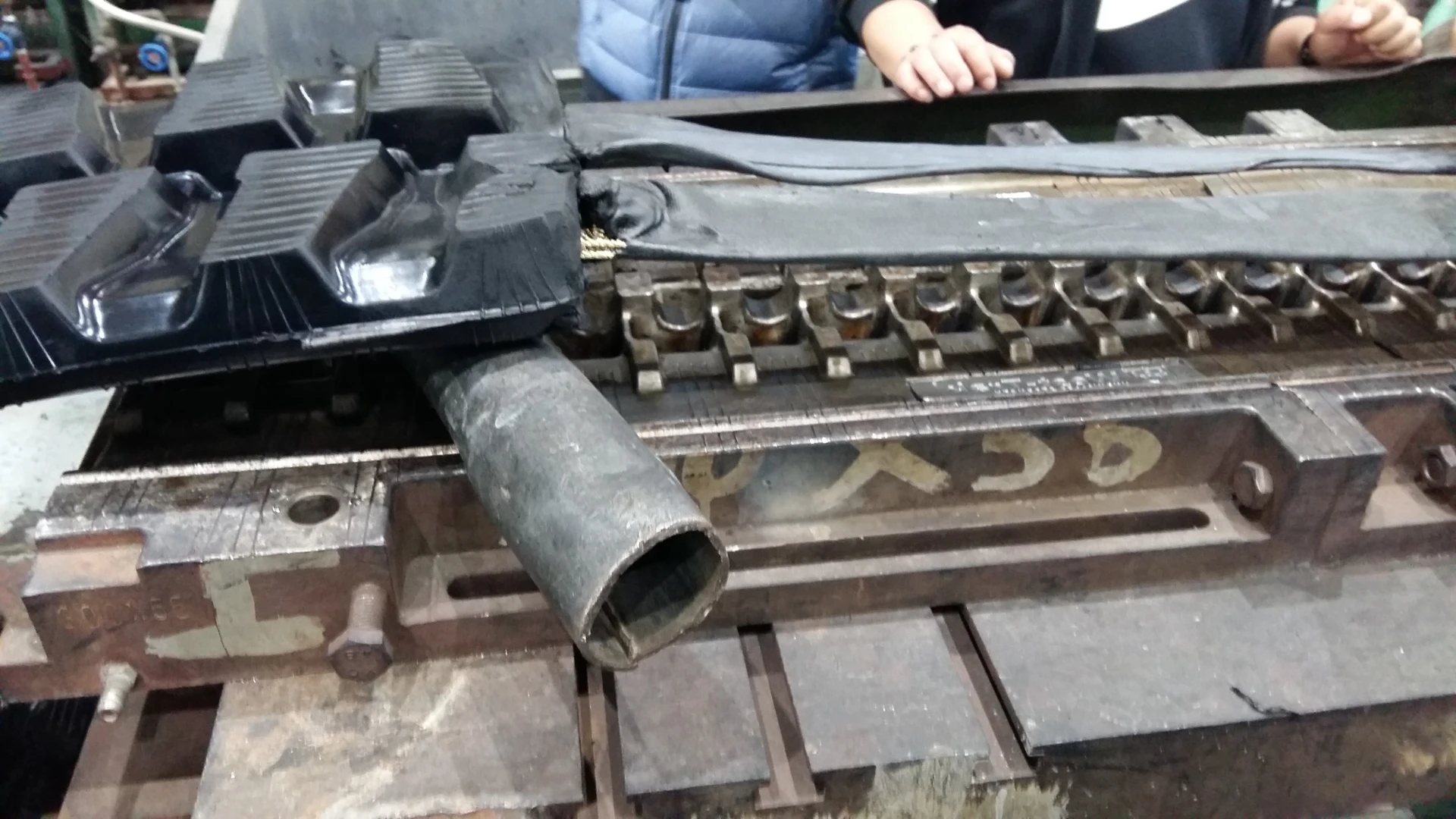 Vulcanisation de la chenille en caoutchouc pour une mini-pelle.